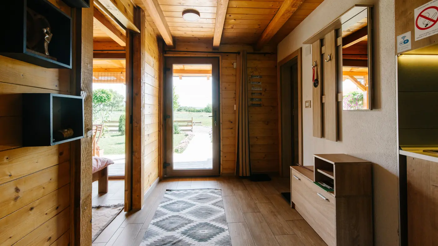 Eingangsbereich mit Holzverkleidung, Teppich und Haustür mit Glaseinsatz